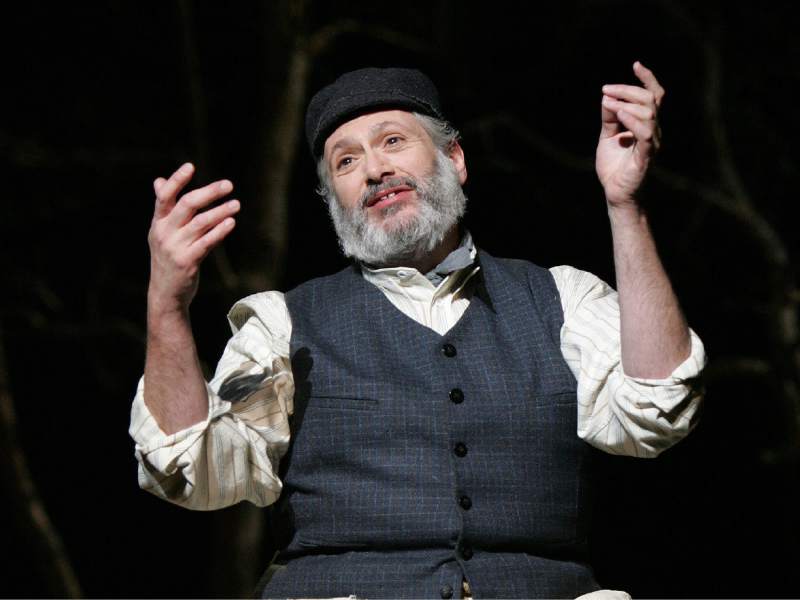 Harvey Fierstein, in the role of Tevye, gestures magnanimously.
