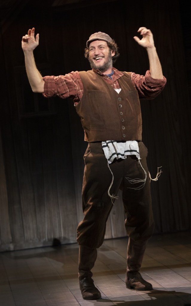 Yehezkel Lazarov, in the role of Tevye, throws up his hands in glee.